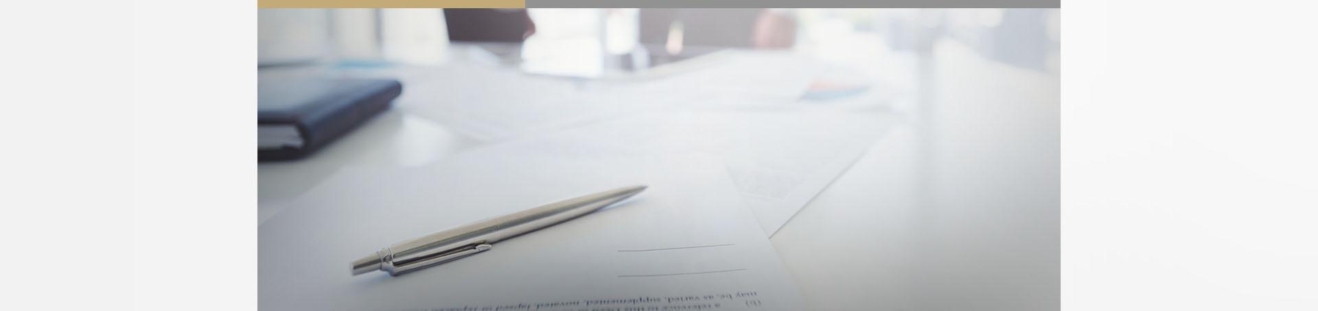 Srebrny długopis leżący na papierach Slajd #3